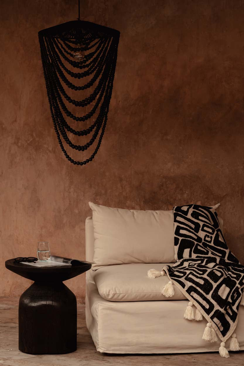 Black beaded chandelier in plastered modern rustic room