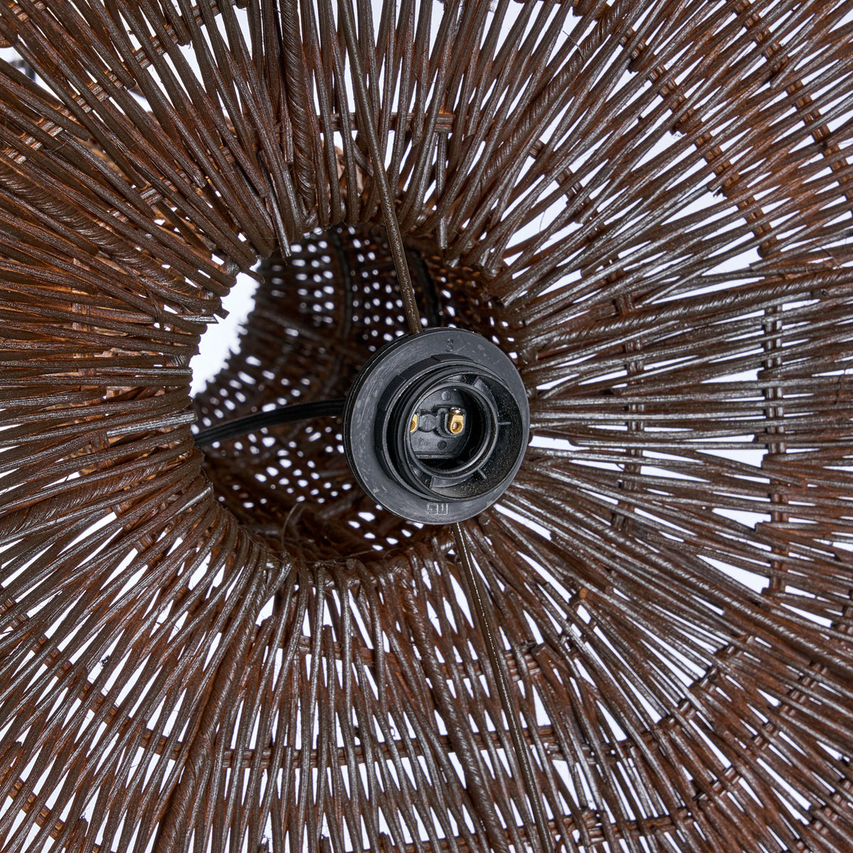 Close up of a wicker rattan pendant light shade with a detailed pattern and central support structure.