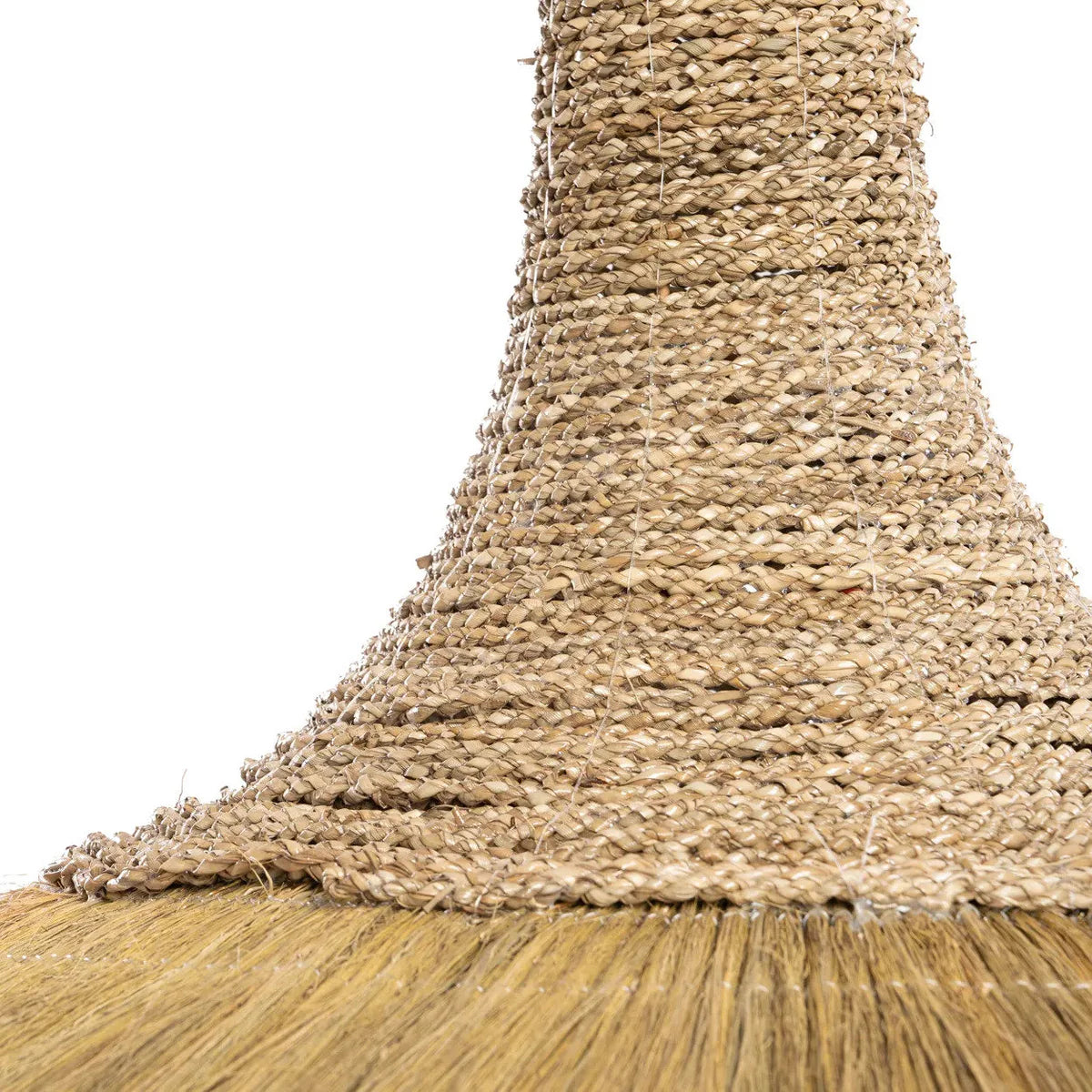 Close up of a natural lightshade with a woven handle and bristle head on a white background