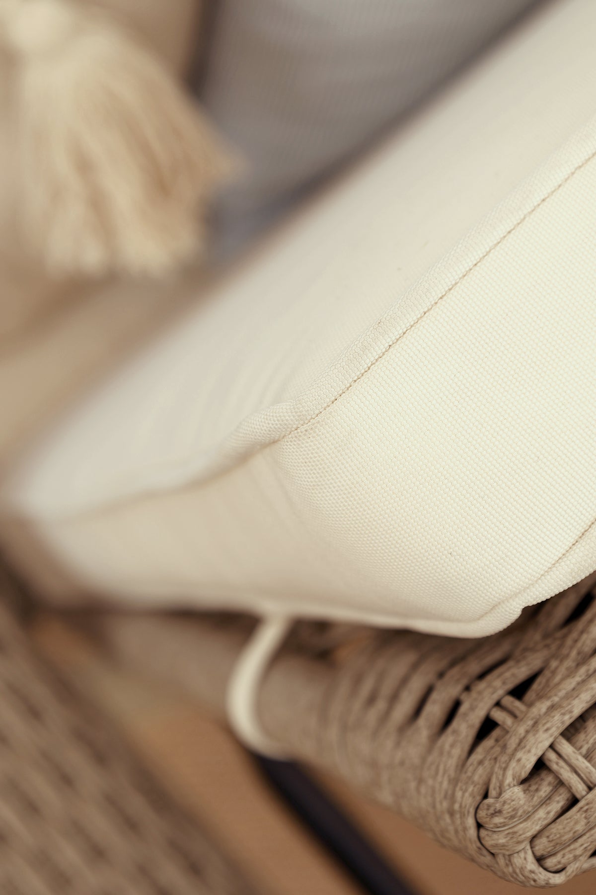 Close up of a beige cushion of a wicker rattan wheeled sun lounger chair