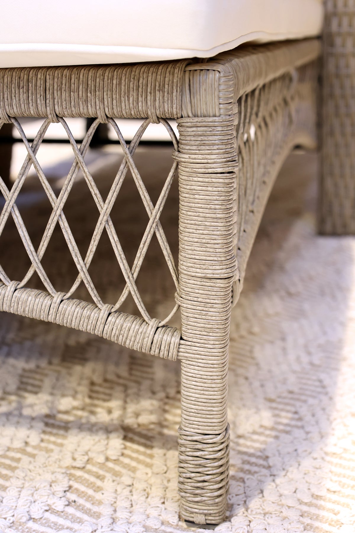 Close up wicker rattan wheeled sun lounger chair frame