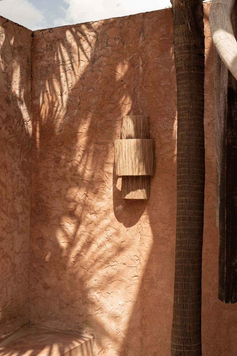Textured wall with a rattan and raffia wall light