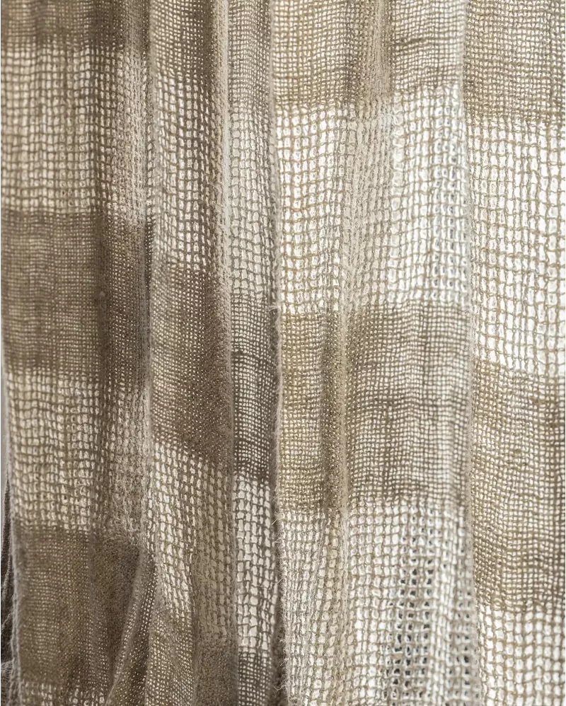Close up of a woven curtain panel with a textured basketweave pattern in beige and taupe tones.
