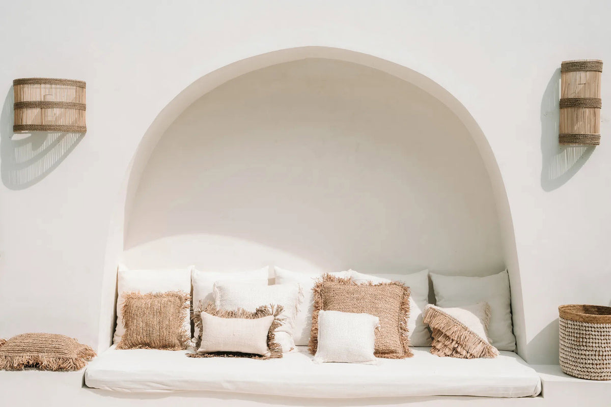 Boho rustic neutral cushions on a day bed with rattan wall lights