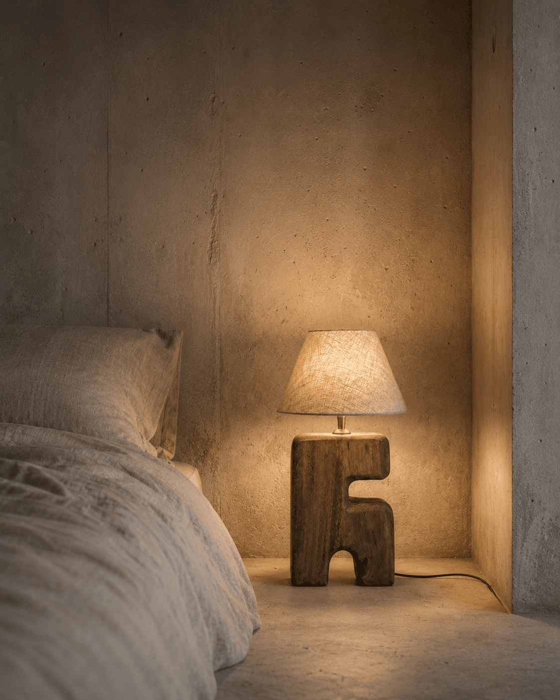 Bedroom with a textured wall, bed, and wooden lamp.