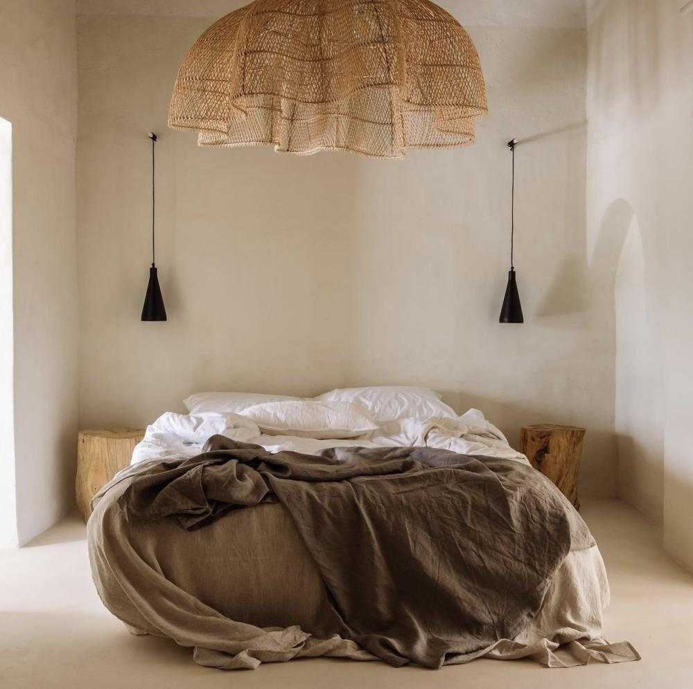 Limewash bedroom with extra large rattan chandelier light over king size bed