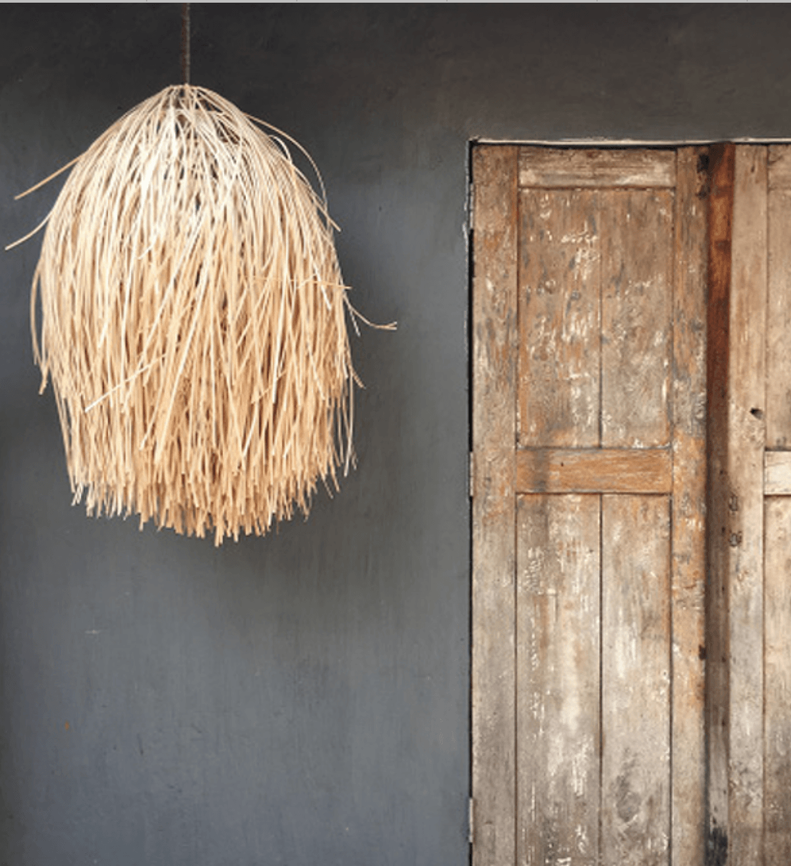 Rustic Rattan Light Shade against a dark painted wall