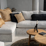 Gray sectional sofa with decorative wabi sabi cushion pillows in a modern living room setting.