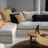 Gray sectional sofa with decorative wabi sabi cushion pillows in a modern living room setting.