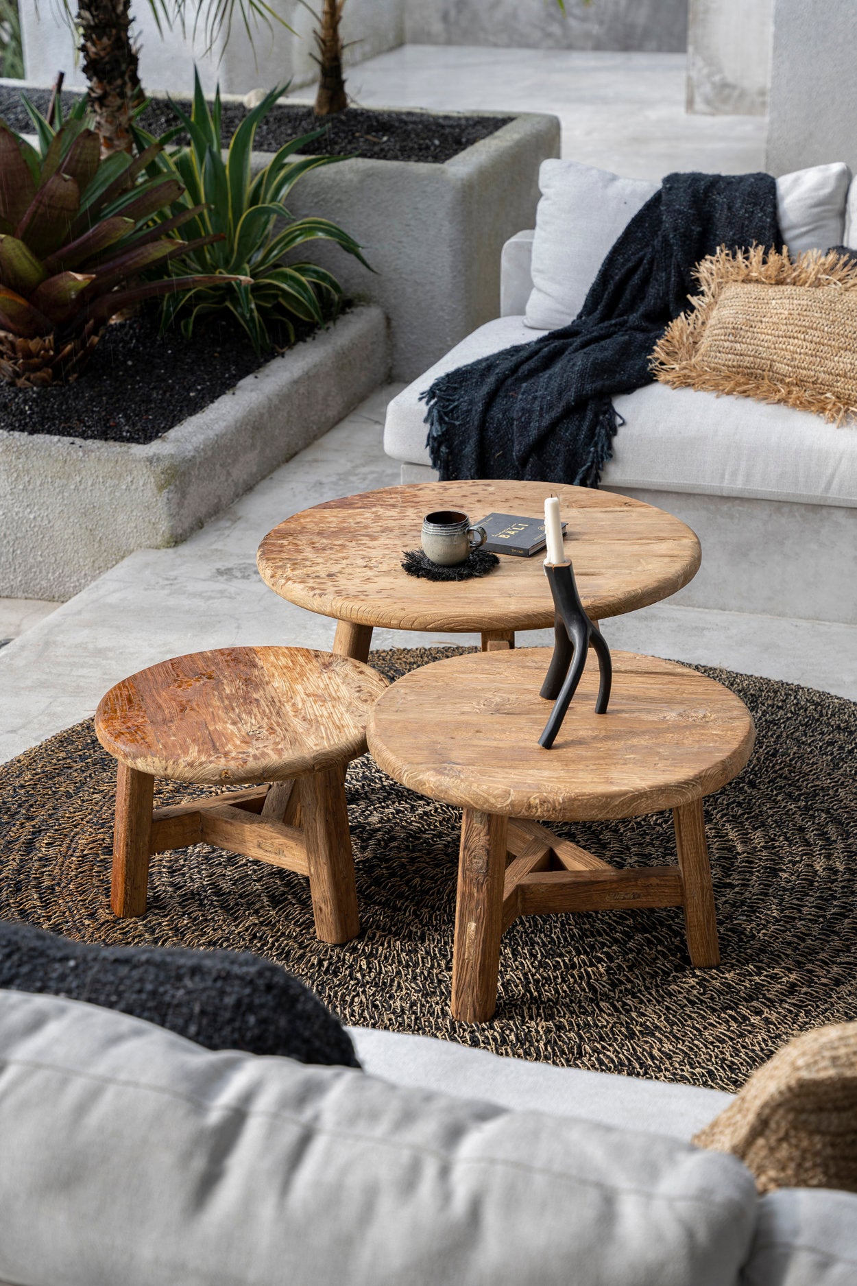 lounge seating area with wooden coffee tables and a white sofa.