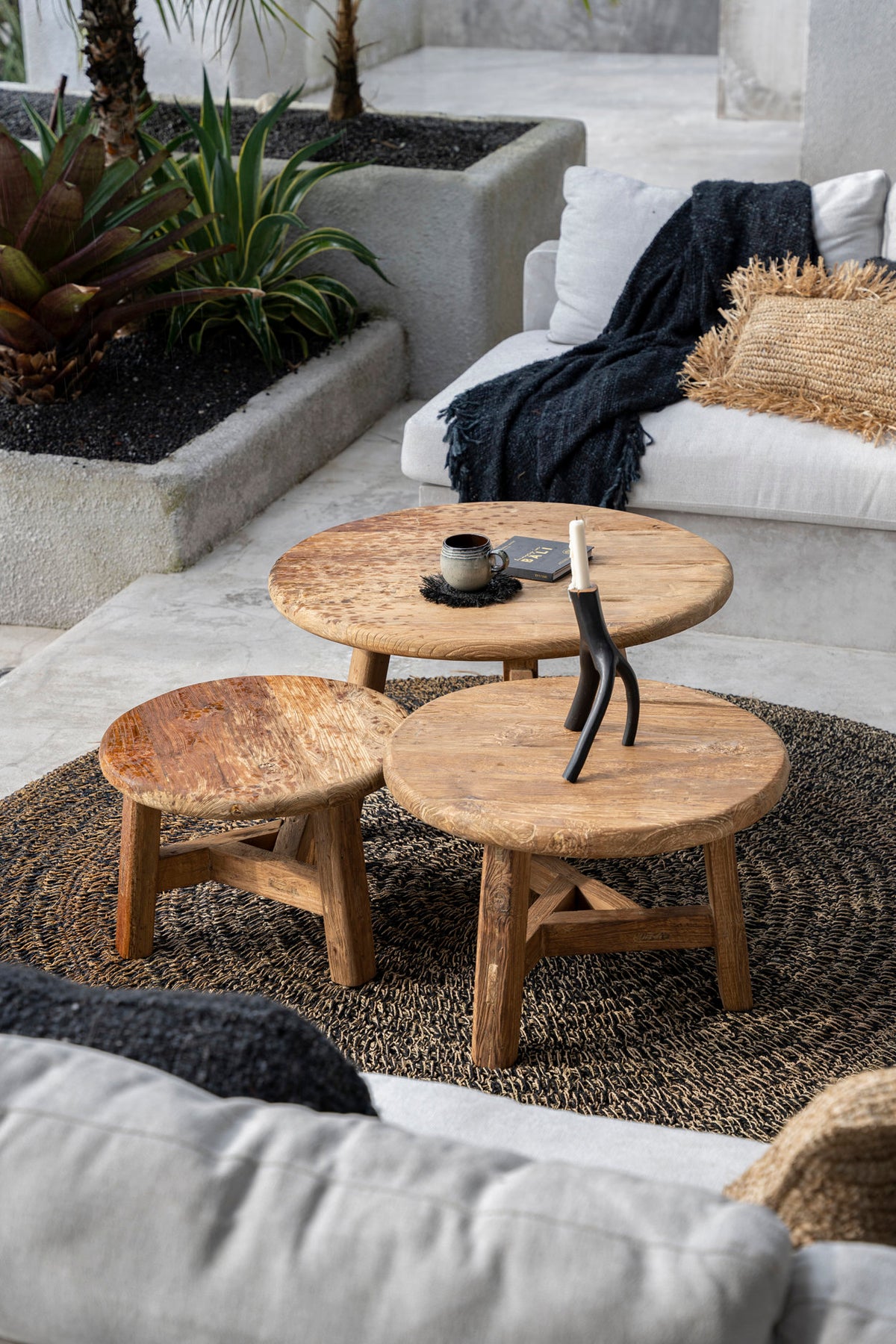Lounge seating area with wooden coffee tables and a white sofa.