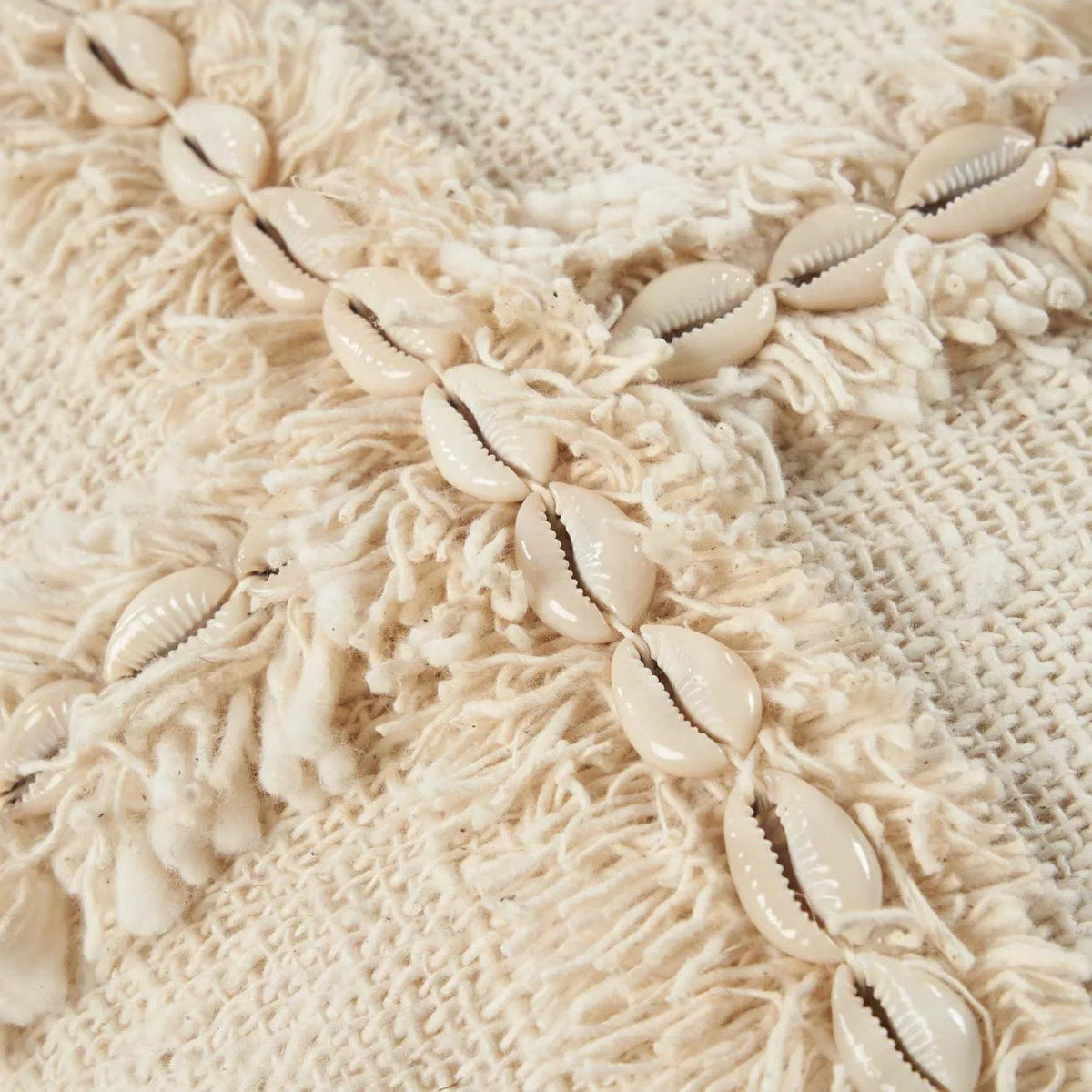 Close up of a decorative cushion cover with shell embellishments 