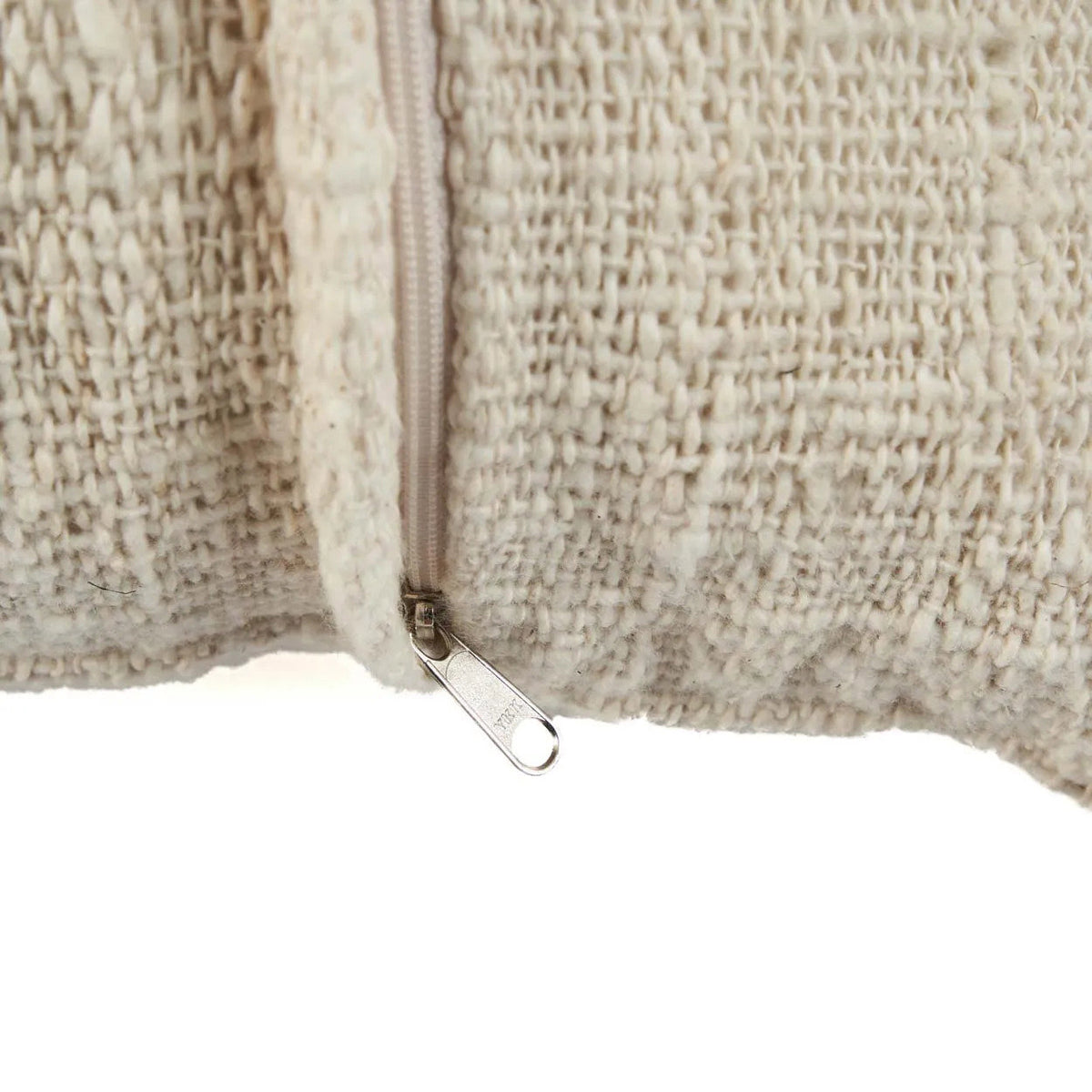Close up of a textured fabric with a zipper on a white background