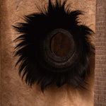 Decorative wall black grass mirror on a textured brown background