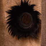 Decorative wall black grass mirror on a textured brown background