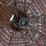 Close-up of a wicker rattan pendant light shade with a detailed pattern and central support structure.