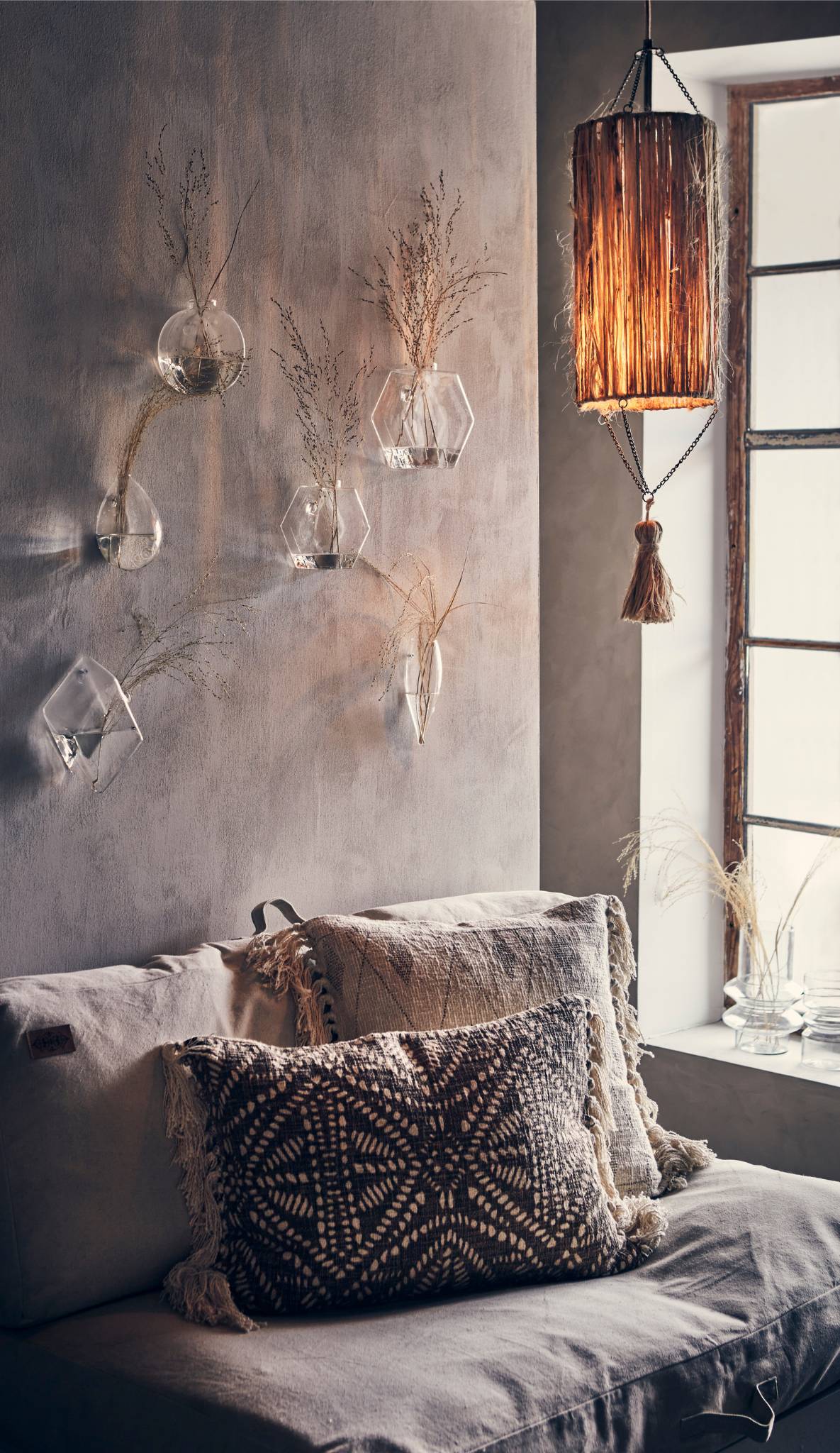 Long raffia pendant light in a wabi sabi style bedroom