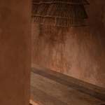 Rustic wooden table with a wicker rattan long statement  pendant light against a textured wall.