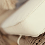 Close-up of a beige cushion of a Wicker rattan  wheeled sun lounger chair 