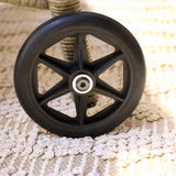 Close-up of a black wheel with metal hub of a Wicker rattan  sun lounger 