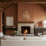 Cosy living room with a fireplace, beige sofa, and large rattan teardrop light shade
