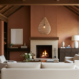 Cosy living room with a fireplace, beige sofa, and large rattan teardrop light shade