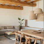 A large dome natural raffia rattan large light shade hanging in a open plan  room - UK