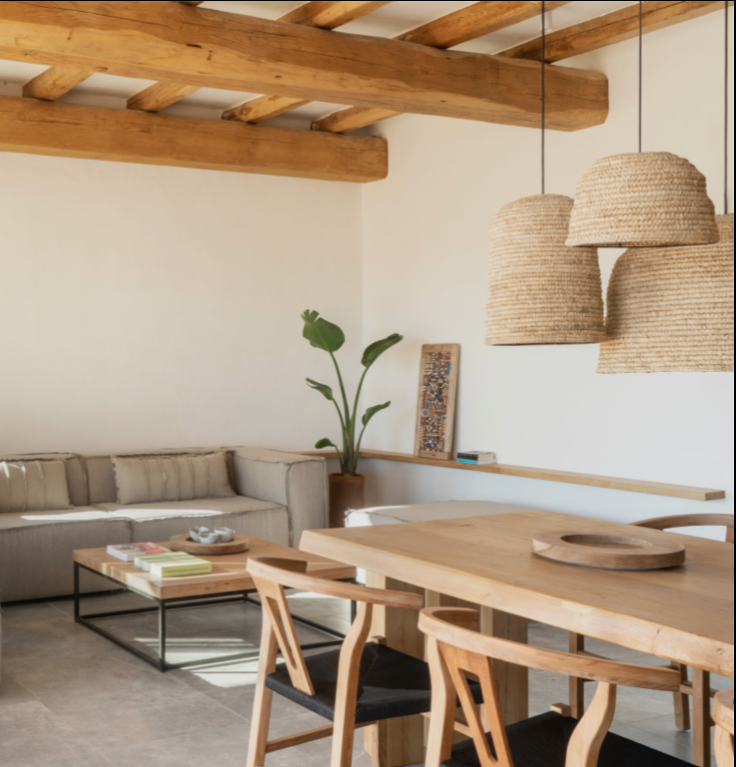 A large dome natural raffia rattan large light shade hanging in a open plan  room - UK