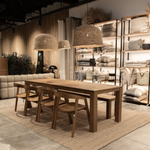 A large natural raffia rattan large light shade hanging above a dining table - UK