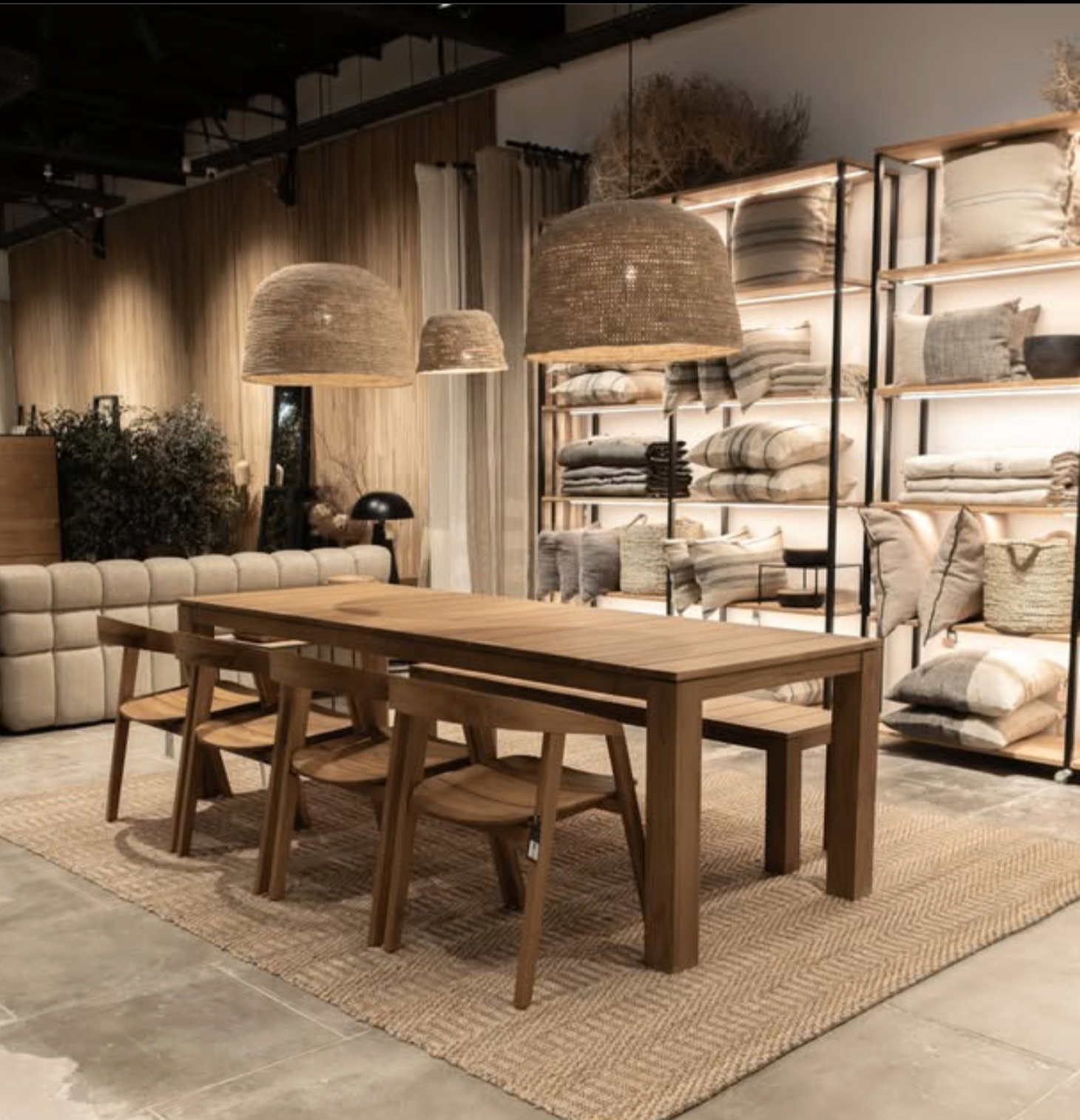 A large natural raffia rattan large light shade hanging above a dining table - UK