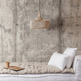 Minimalist interior with a white sofa against a textured concrete wall.