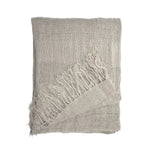 A folded linen curtain panelt in a light taupe-beige colour with fringed edges, displayed on a clean white background.