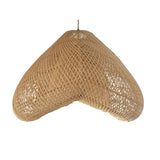 Woven pendant light with tassels hanging against a wooden wall.