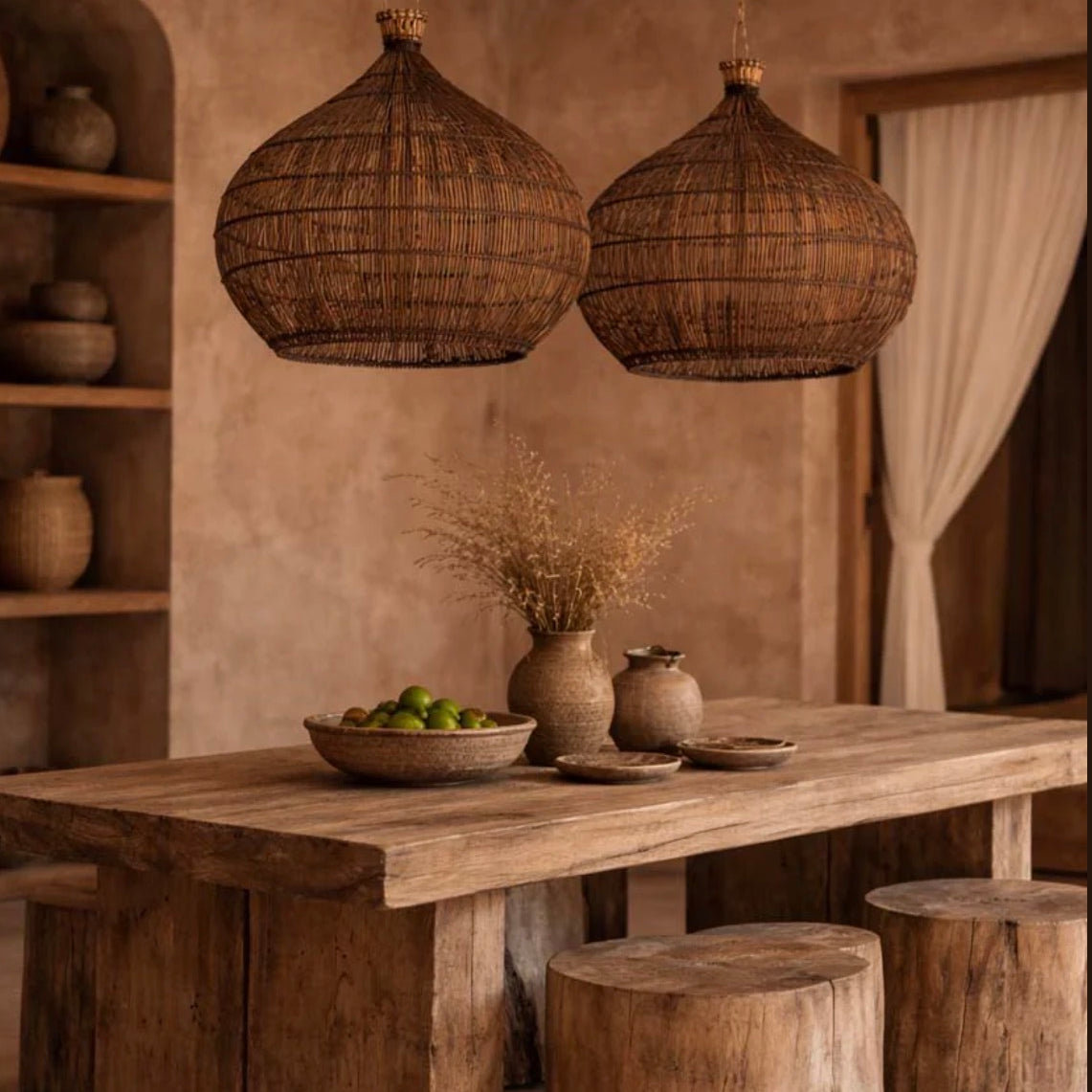 Kitchen Dining area with wooden table, stools, and hanging woven rattan  light shades  in a warm-toned room.