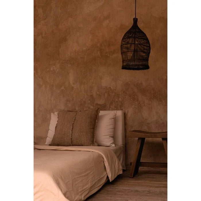 Bedroom with brown walls, bed, and dark rattan pendant light shade as bedside lamp