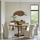 Dining room with a wooden table and chairs, featuring a wicker rattan  pendant light.