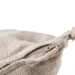 Close-up of a textured beige cushion zip with a zipper on a white background