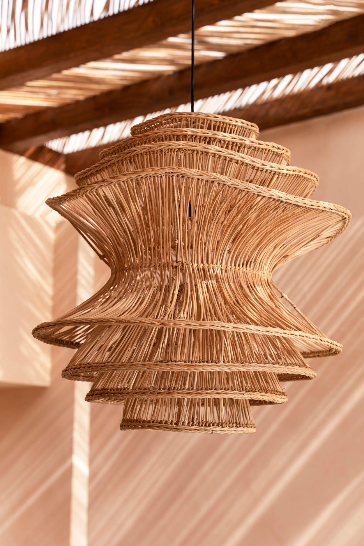 Woven wicker rattan pendant light hanging from a wooden ceiling