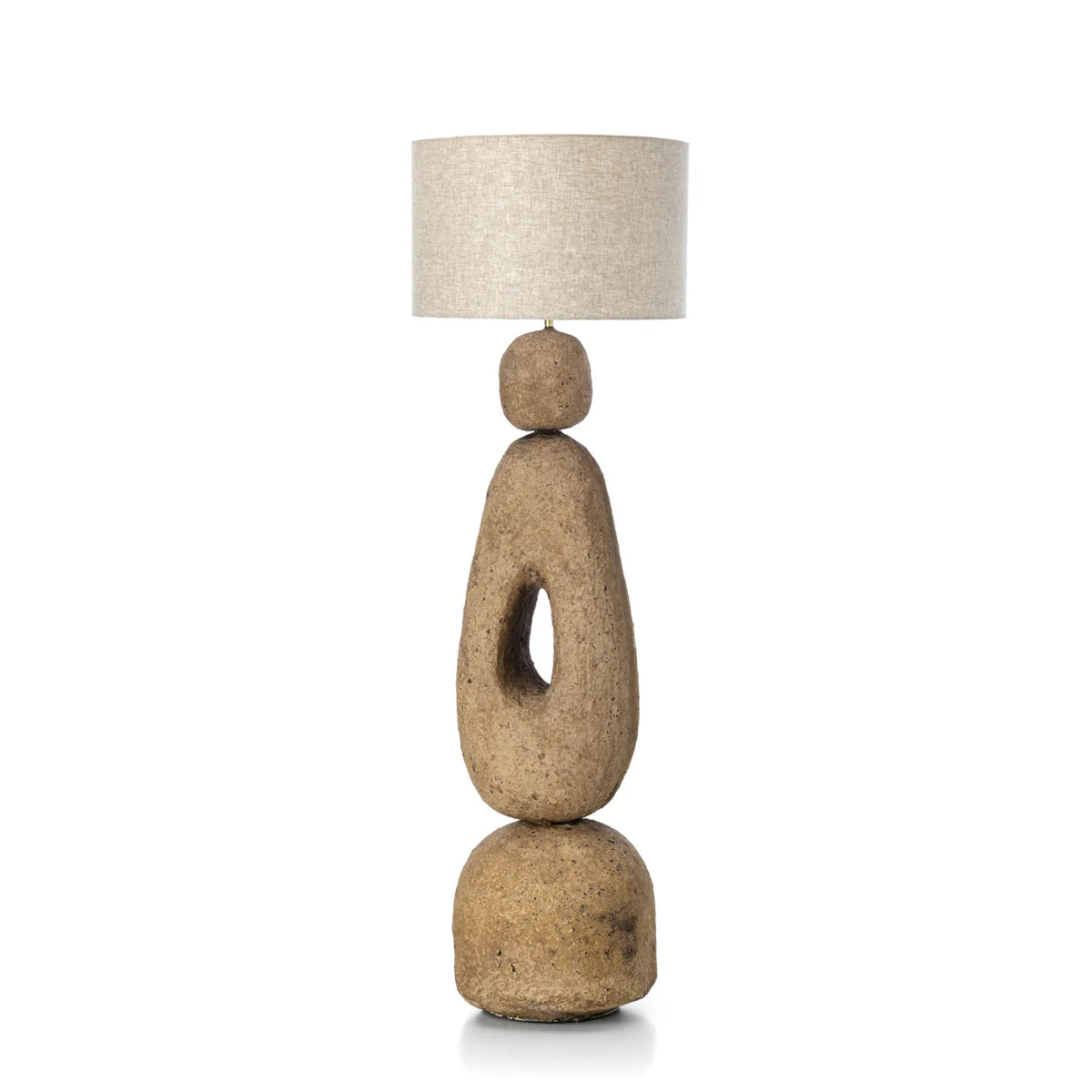 Floor standard lamp with an earthy textured base and linen shade on a white background