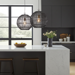Modern kitchen with black pendant lights, white marble island, and dark cabinets.