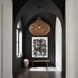 extra large rattan ceiling light Modern interior hallway with dark walls, a wooden bench, and a hanging light fixture.