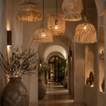 Decorative hallway with hanging wicker rattan light shades and potted plants.