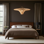 Modern bedroom with a wooden bed, oversized rattan pendant light, and side tables.