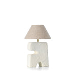 Table lamp with textured white base and beige lampshade on a white background