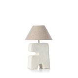 Table lamp with textured white base and beige lampshade on a white background