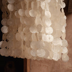close up of natural shells on a a pendant light chandelier in bedroom
