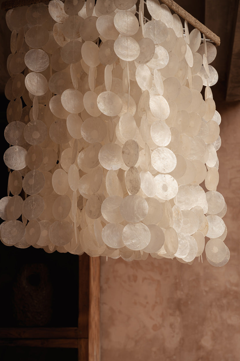 Close up of natural shells on a a pendant light chandelier in bedroom
