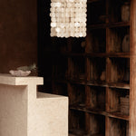 Long hanging shell chandelier hanging in a terracotta rustic kitchen living room
