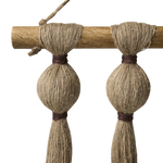 Close up of a wall hanging wooden pole and jute cotton strands