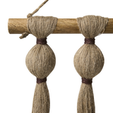 Close up of a wall hanging wooden pole and jute cotton strands